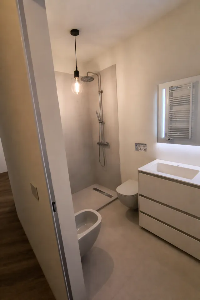 Bagno con sanitari sospesi e box doccia in vetro