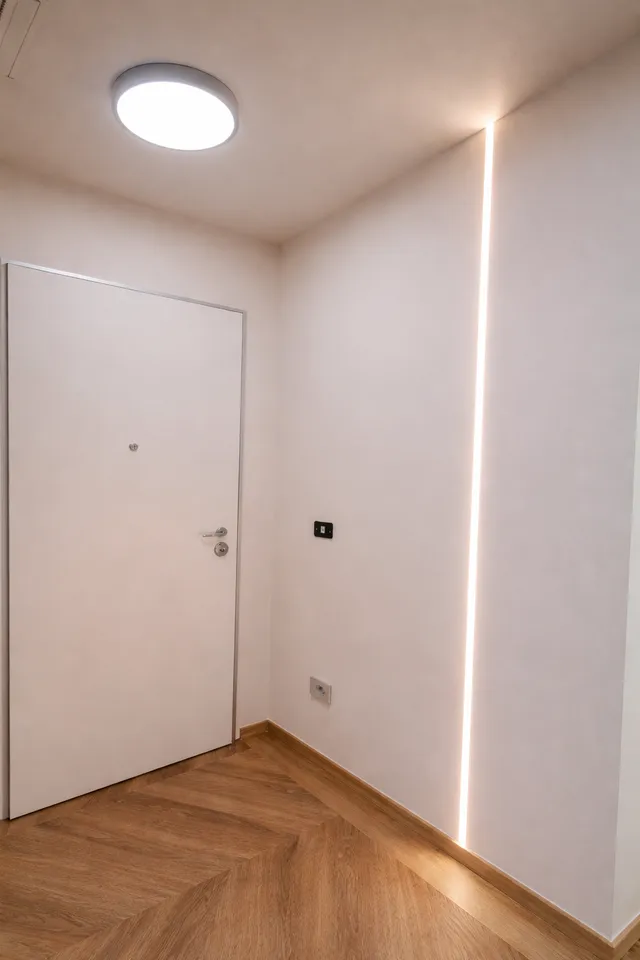 Ingresso con porta blindata bianca e luce LED a parete