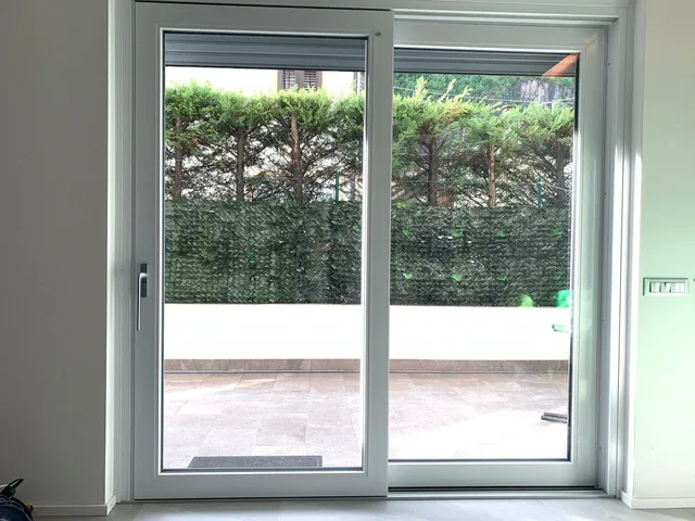 Portafinestra scorrevole bianca installata su un giardino